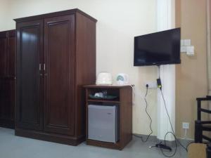a living room with a tv and a wooden cabinet at Janishi Residencies in Negombo