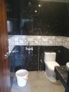 拉特納吉里的住宿－Samarth Homestay，一间带卫生间和黑色墙壁的浴室