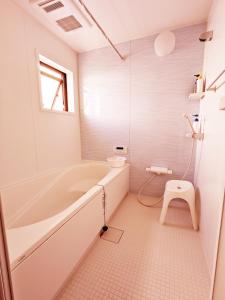 baño blanco con bañera y aseo en Rosenheim Tokyo Shinjuku Okubo, en Tokio