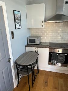 eine kleine Küche mit Tisch und Mikrowelle in der Unterkunft Modern One Bedroom Chalet with Central Heating in Bridlington + 4 Fotos