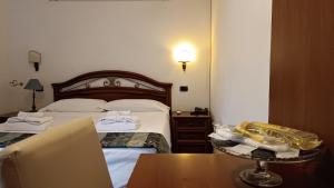 a hotel room with two beds and a table at EURO HOUSE INN airport in Fiumicino