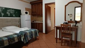 a room with a bed and a desk and a kitchen at EURO HOUSE INN airport in Fiumicino