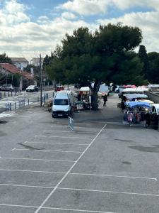 una furgoneta estacionada en un estacionamiento junto a un árbol en Coquette maison à 500 m de la plage du verdon à la couronne, en Martigues