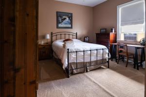 a bedroom with a bed and a desk and a window at Exquisite Victorian in Springfield