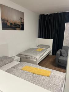 pokój z 2 łóżkami i krzesłem w obiekcie Messe privat Wohnung Vermietung w Hanowerze