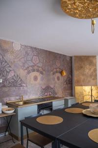 une cuisine avec une table et un mur orné d'une fresque murale. dans l'établissement DOMUS GALLA PLACIDIA - superlative view - 50 meters from the UNESCO heritage sites - San Vitale - Galla Placidia, à Ravenne