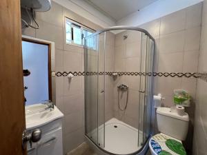 a bathroom with a shower and a toilet and a sink at Casa shalet piriapolis 6 personas in Bella Vista +21 photos