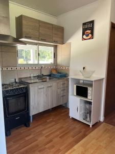 a kitchen with a sink and a stove at Casa shalet piriapolis 6 personas in Bella Vista