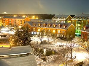 a city at night with snow and buildings at Garden City Apartment, Helsinki - Vantaa Airport in Vantaa
