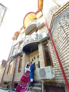 um homem e uma mulher em frente a um edifício em Samarkand Сity Guest House em Samarcanda