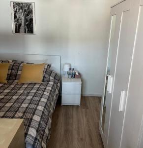 a small bedroom with a bed and a night stand at 2 privé verdiepingen in stadswoning, bij Station en centrum in Venlo