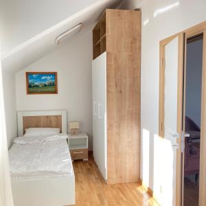um quarto com uma cama e uma parede de madeira em Zvezda 3 Zlatar em Nova Varoš