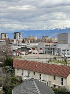 a city with buildings and mountains in the background at magnifique Duplex avec 2 chambres et parking gratuit in Grenoble