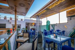 um restaurante com mesas azuis e cadeiras numa varanda em Riad Glatt K em Marrakech