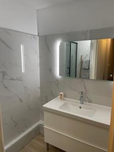 a white bathroom with a sink and a mirror at magnifique Duplex avec 2 chambres et parking gratuit in Grenoble +19 photos