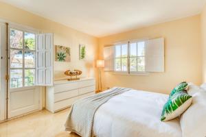 een slaapkamer met een groot wit bed en ramen bij Life El Presidente Penthouse Pool View in Estepona