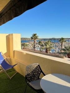 uma varanda com cadeiras e vista para a praia em Appartement sur le port vue Mer em Bandol