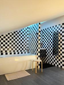 uma casa de banho com banheira e parede em xadrez em Appartement sur le port vue Mer em Bandol