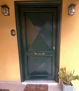 una puerta negra con una ventana de cristal junto a una planta en Casa Gaeta, en Gaeta