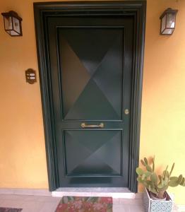 a black door with a glass window next to a plant at Casa Gaeta in Gaeta