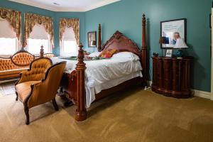 um quarto com uma cama grande e uma cadeira em Exquisite Victorian em Springfield