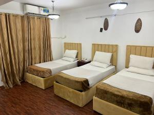 2 camas en una habitación de hotel con cortinas en Sport Hotel, en Dubái