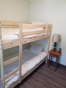 two bunk beds in a room with a lamp and a table at Whitney Bay House on CHQ Lake in Mayville