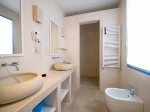 Baño blanco con lavabo y aseo en La Naca sul Mare - Suite, en Nardò