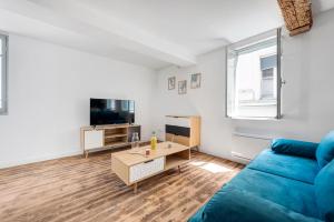 a living room with a blue couch and a table at Les studios Jean Bringer - Carcassonne centre-ville in Carcassonne +13 photos