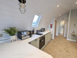 a large kitchen with white countertops and a window at Gopsall Hall Farm in Atherstone