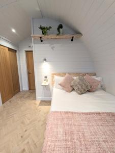 Un dormitorio con una cama blanca con almohadas. en Gopsall Hall Farm, en Atherstone