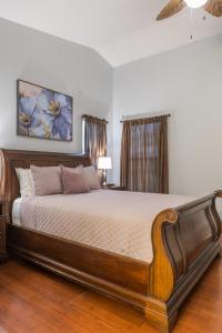 1 dormitorio con 1 cama grande de madera en una habitación en Cozy House w pool Near State Farm Stadium, en Glendale