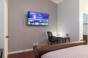 1 dormitorio con 1 cama y TV en la pared en Cozy House w pool Near State Farm Stadium, en Glendale