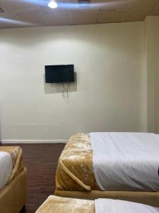Habitación con 2 camas y TV de pantalla plana. en Sport Hotel, en Dubái