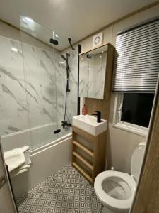 a small bathroom with a toilet and a sink at Coastal caravan with superb view in Bembridge