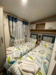 a small bedroom with two beds in it at Coastal caravan with superb view in Bembridge