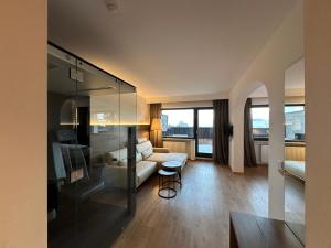 een woonkamer met een bank en een tafel bij Royal Hotel Hinterhuber in Brunico