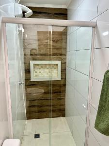 a shower with a glass door in a bathroom at LOFT IGUASSU FALLS *GARAGEM* in Foz do Iguaçu