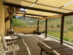un patio con tavolo, sedie, tavolo e panche di Agriturismo Dacapo ad Agliano Terme