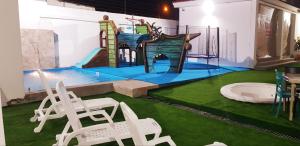 a play area with two chairs and a slide at Hotel Villa Del Mar in Salinas