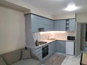 cocina con armarios blancos y sofá en ALIANCE апартамети в центрі міста., en Ivano-Frankivsk