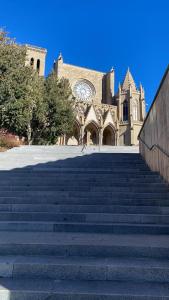 a building with stairs in front of a church at Apartaments Puigcardener BX in Manresa