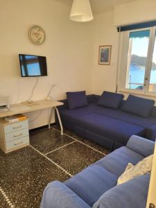 a living room with a blue couch and a desk at Attico Vista Mare Sestri Levante in Sestri Levante