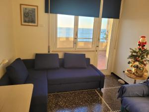 a living room with a blue couch and a christmas tree at Attico Vista Mare Sestri Levante in Sestri Levante