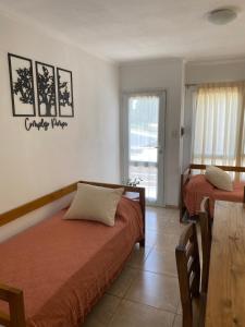 1 dormitorio con 2 camas, mesa y ventana en Complejo Pampa 2 en Santa Rosa