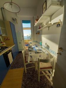 a kitchen with a table and a table and a window at Attico Vista Mare Sestri Levante in Sestri Levante