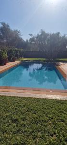 une grande piscine au milieu d'une cour dans l'établissement VILLA ROSERAIE, à Marrakech