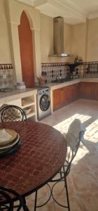 a kitchen with a table and chairs and a stove at VILLA ROSERAIE in Marrakech
