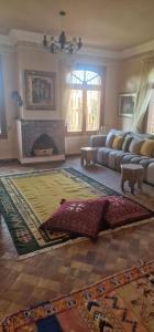 a living room with a couch and a fireplace at VILLA ROSERAIE in Marrakech