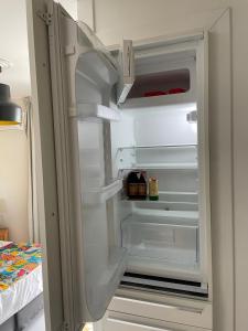 an empty refrigerator with its door open in a room at Plaisir Caraïbes in Belle-Allée